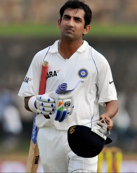 "Indian cricketer Gautam Gambhir, wearing a cricket jersey, standing confidently on the field with his bat."