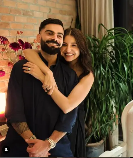 "Virat Kohli with his wife, Anushka Sharma, smiling together at a public event."

