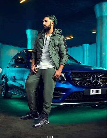 "Yuvraj Singh posing confidently in a stylish suit with a luxurious background, symbolizing his wealth and success."