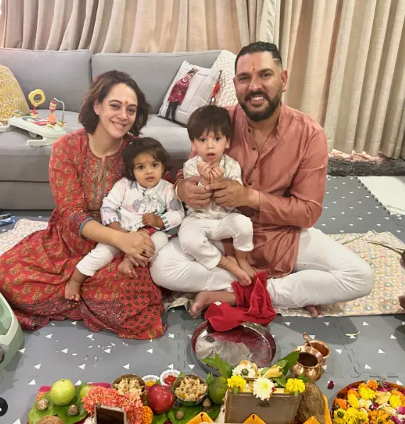 Yuvraj Singh smiling with his family, including his parents, wife Hazel Keech, and son, sharing a heartwarming moment together."

