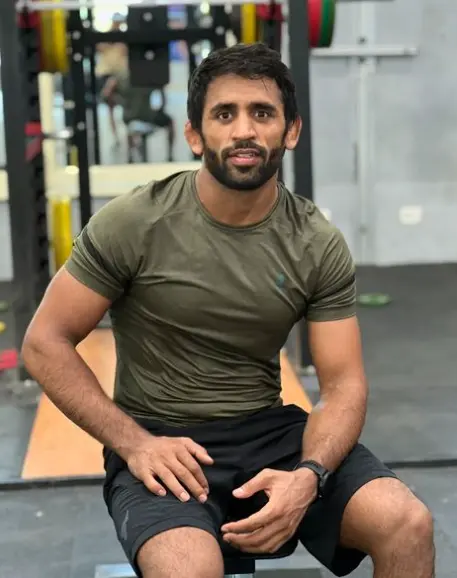 "Bajrang Punia, Indian wrestler, standing confidently with medals around his neck, symbolizing his illustrious wrestling career."

