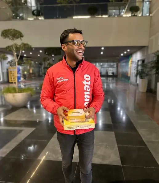 Deepinder Goyal, founder and CEO of Zomato, standing confidently in a business setting, representing his leadership in the food delivery industry.