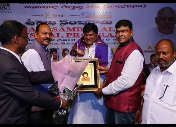 "Rajendra Prasad holding an award, recognized for his outstanding contributions to Telugu cinema."